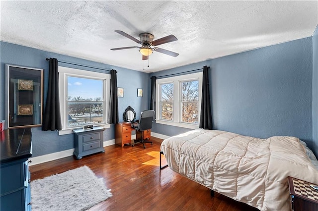 bedroom featuring dark wood-type flooring, ceiling fan, and a textured ceiling