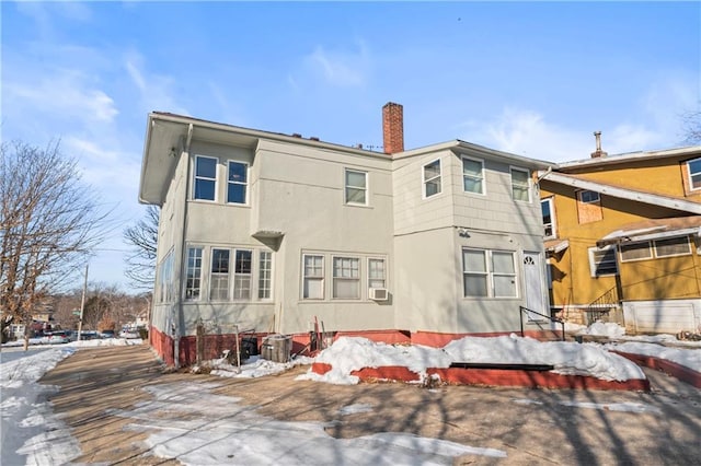 snow covered property featuring cooling unit