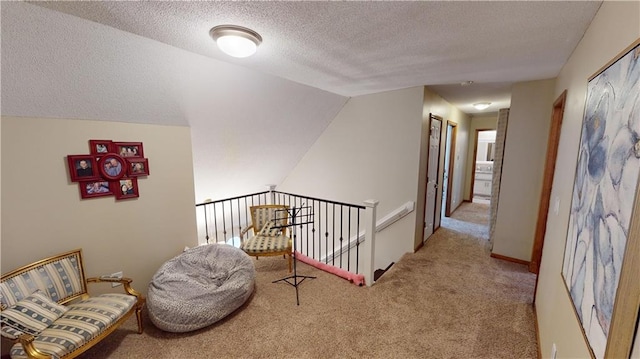 living area featuring light colored carpet, vaulted ceiling, and a textured ceiling