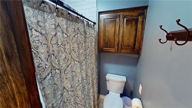 bathroom featuring toilet and a shower with curtain