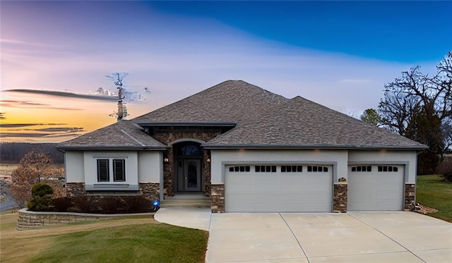 prairie-style home featuring a garage and a lawn