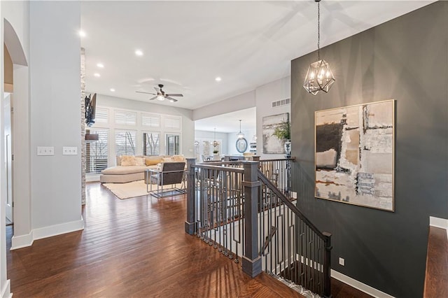 hallway with dark hardwood / wood-style floors and a notable chandelier