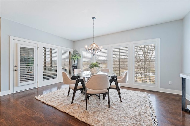 dining area featuring dark wood-type flooring and a chandelier