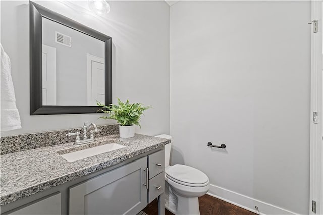 bathroom with vanity, wood-type flooring, and toilet