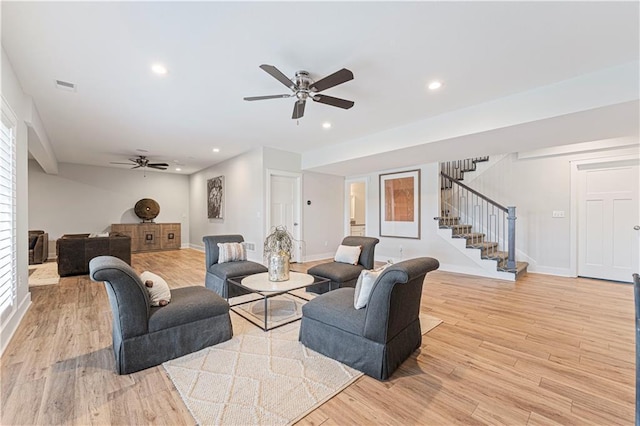 living room with ceiling fan and light hardwood / wood-style flooring