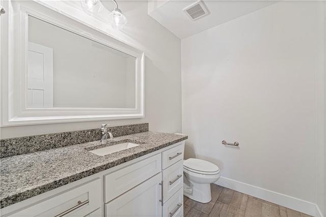 bathroom with wood-type flooring, toilet, and vanity