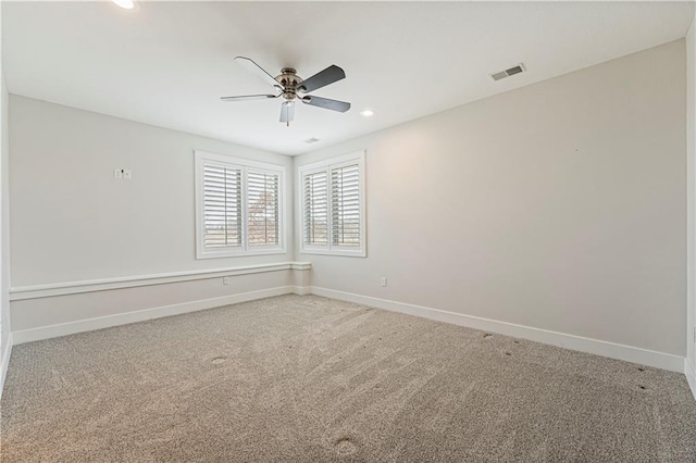 carpeted spare room with ceiling fan