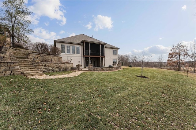 rear view of house with a yard and a sunroom