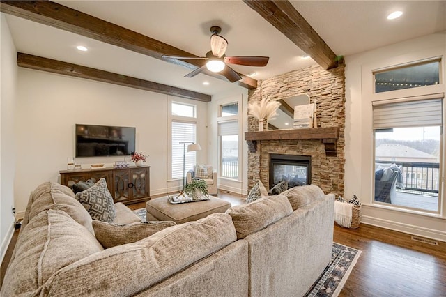 living room with beam ceiling, dark hardwood / wood-style flooring, plenty of natural light, and a fireplace