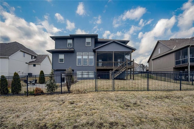 rear view of property featuring a yard and a sunroom