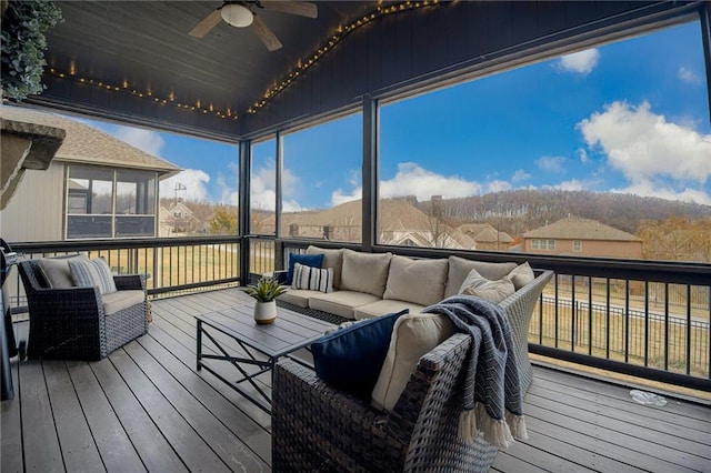 wooden deck with ceiling fan, outdoor lounge area, and a sunroom