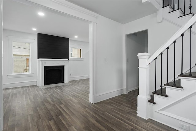 interior space with dark hardwood / wood-style flooring and a large fireplace