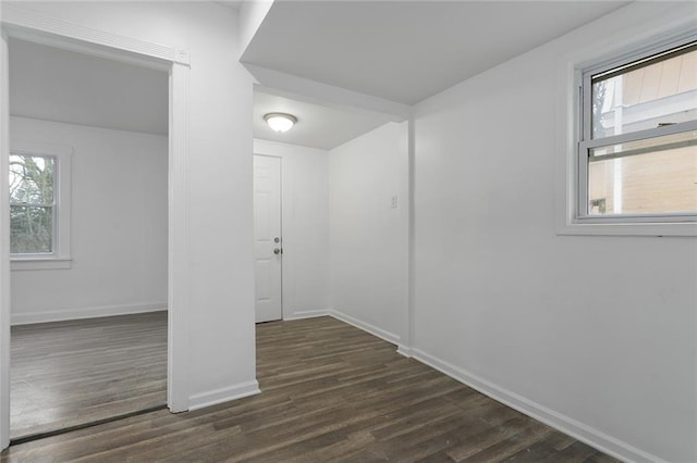 spare room featuring plenty of natural light and dark wood-type flooring