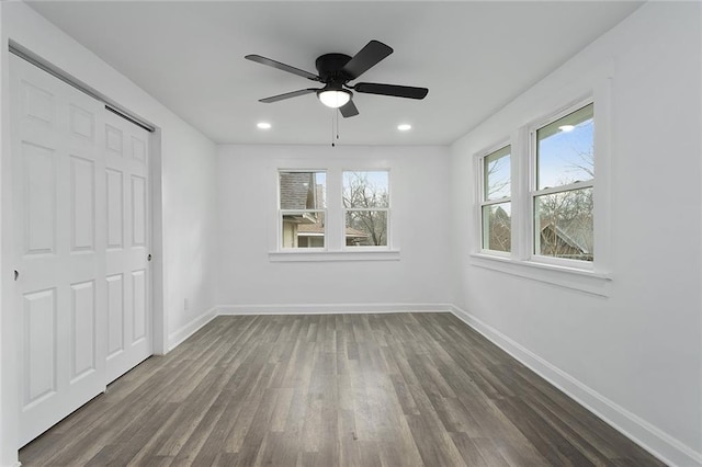 unfurnished bedroom with ceiling fan and dark wood-type flooring