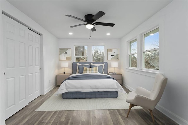 bedroom with hardwood / wood-style floors, a closet, and ceiling fan