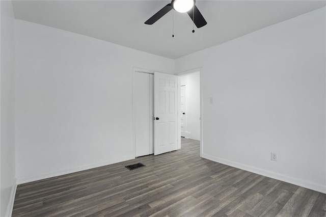 empty room with dark hardwood / wood-style flooring and ceiling fan