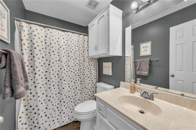 bathroom with a shower with curtain, vanity, toilet, and a textured ceiling