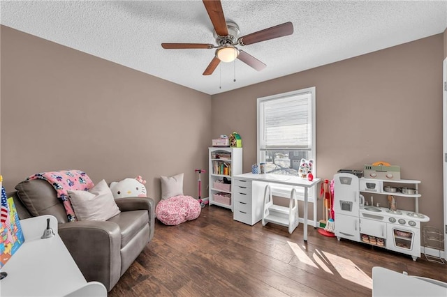 recreation room featuring a textured ceiling, ceiling fan, and dark wood-type flooring