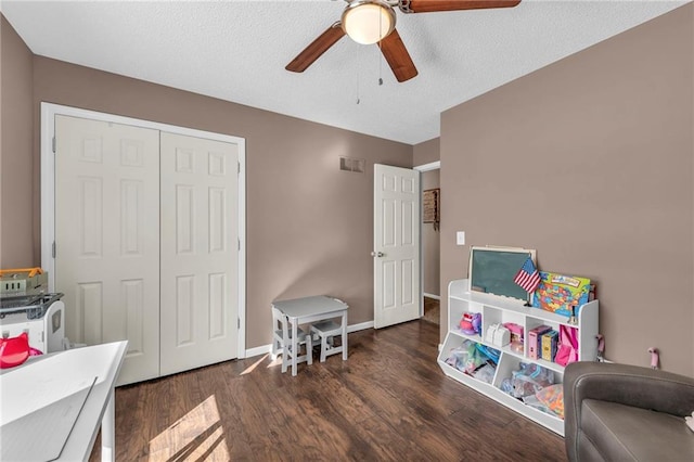 rec room featuring ceiling fan, dark hardwood / wood-style flooring, and a textured ceiling