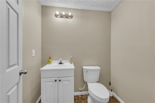 bathroom featuring vanity, toilet, and a textured ceiling