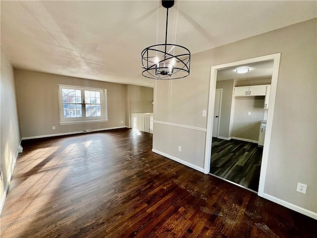 unfurnished dining area with a notable chandelier and dark hardwood / wood-style floors