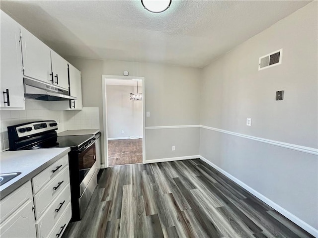 kitchen featuring white cabinetry, tasteful backsplash, dark hardwood / wood-style flooring, a textured ceiling, and stainless steel electric stove