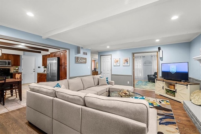 living room with ornamental molding, beam ceiling, and hardwood / wood-style floors