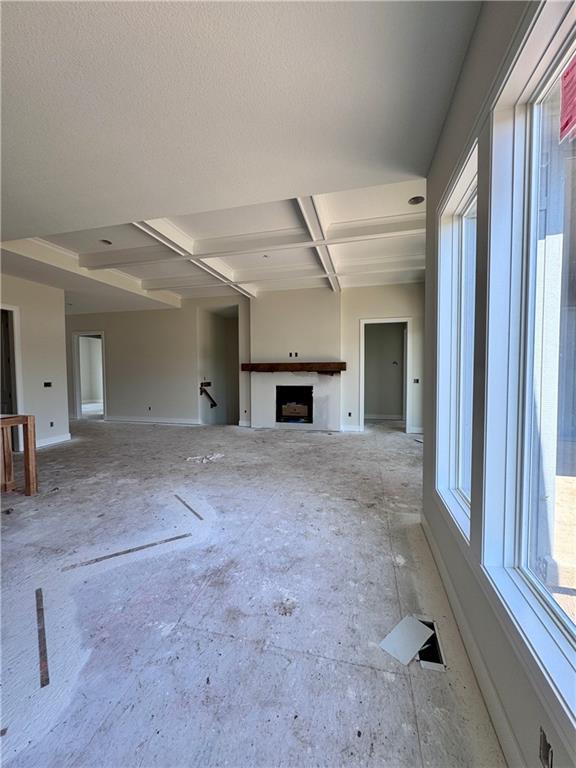 4218 W 158th Ter, Overland Park, KS 66224 - unfurnished living room with coffered ceiling, exterior fireplace, and beam ceiling
