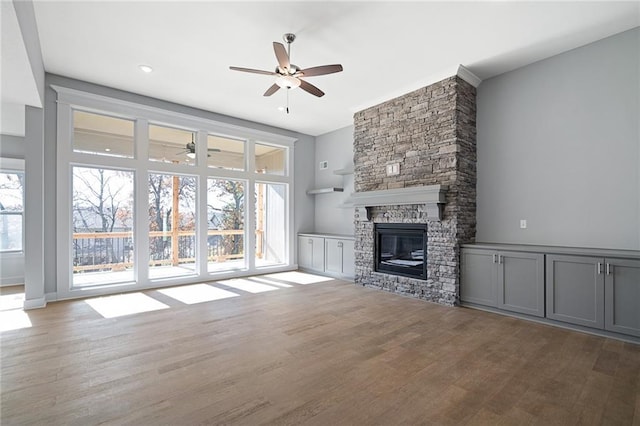 19692 W 114th St, Olathe, KS 66061 - unfurnished living room featuring a ceiling fan, healthy amount of natural light, wood finished floors, and a fireplace