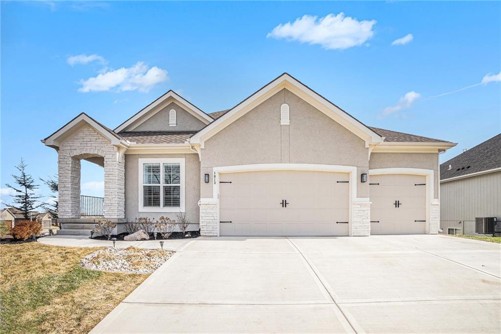 view of front of home with a garage and central air condition unit