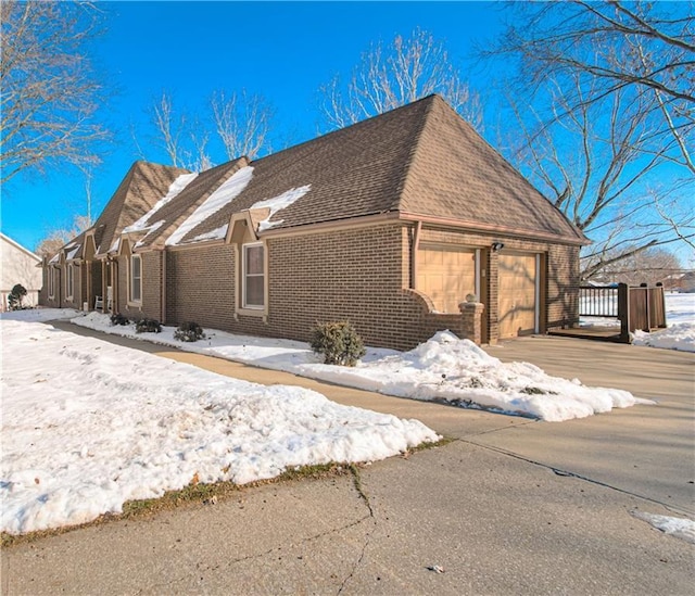 view of snow covered exterior featuring a garage