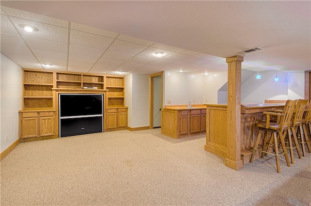 bar with sink, built in features, and light colored carpet