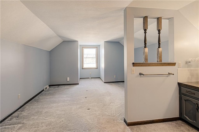 additional living space with light carpet and lofted ceiling