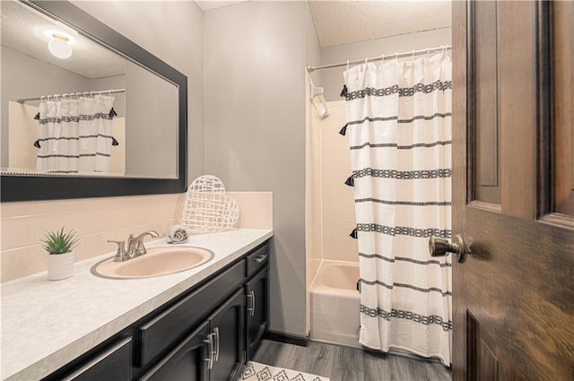 bathroom featuring a textured ceiling, shower / tub combo, hardwood / wood-style floors, tasteful backsplash, and vanity