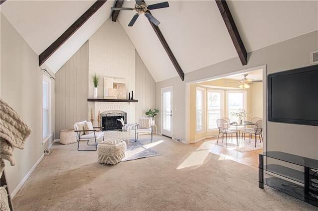 living room featuring a brick fireplace, high vaulted ceiling, ceiling fan, and beamed ceiling