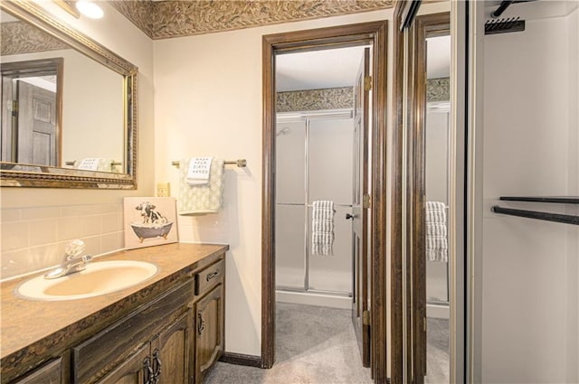 bathroom with an enclosed shower, vanity, and decorative backsplash