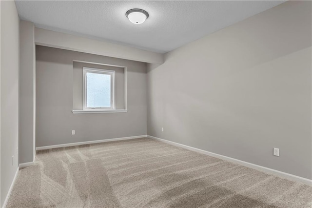 carpeted empty room featuring a textured ceiling