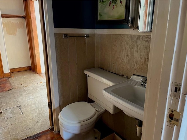 4512 Terrace St, Kansas City, MO 64111 - bathroom featuring wood walls, toilet, and sink