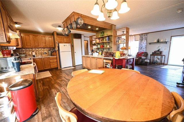 dining room featuring dark hardwood / wood-style flooring, plenty of natural light, and a notable chandelier