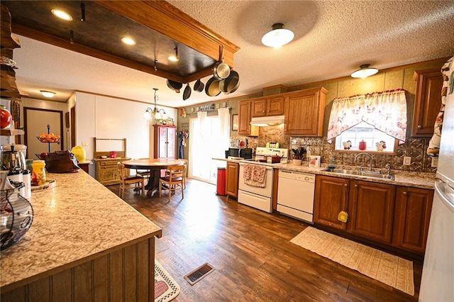 kitchen featuring sink, dark hardwood / wood-style floors, pendant lighting, white appliances, and decorative backsplash