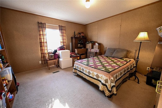 bedroom featuring carpet, ornamental molding, and a textured ceiling