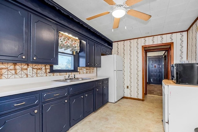 kitchen with blue cabinetry, ornamental molding, sink, and white fridge