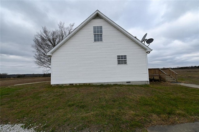 view of side of property featuring a wooden deck and a lawn