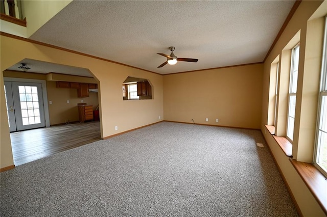 unfurnished room featuring carpet flooring, ceiling fan, ornamental molding, and a textured ceiling