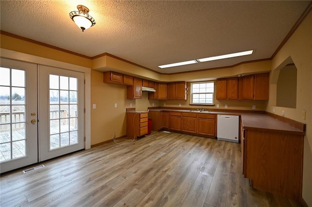 kitchen with dishwasher, light hardwood / wood-style floors, crown molding, and french doors