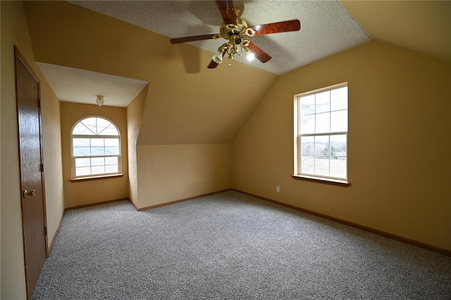 bonus room with carpet, a wealth of natural light, a textured ceiling, and ceiling fan