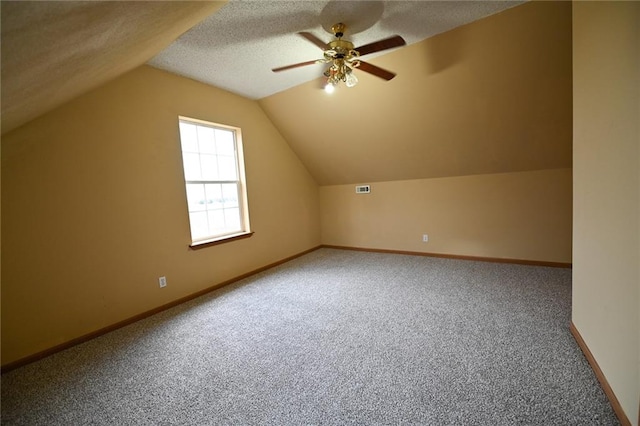 bonus room featuring a textured ceiling, carpet floors, vaulted ceiling, and ceiling fan