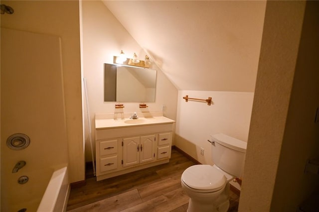 full bathroom with washtub / shower combination, hardwood / wood-style floors, vaulted ceiling, toilet, and vanity