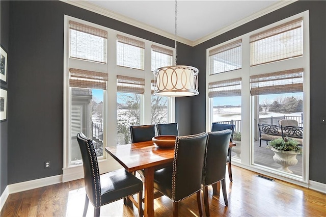 dining space featuring hardwood / wood-style flooring and crown molding