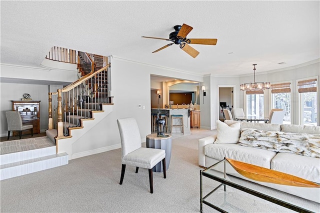 living room featuring ornamental molding, ceiling fan with notable chandelier, light colored carpet, and a textured ceiling